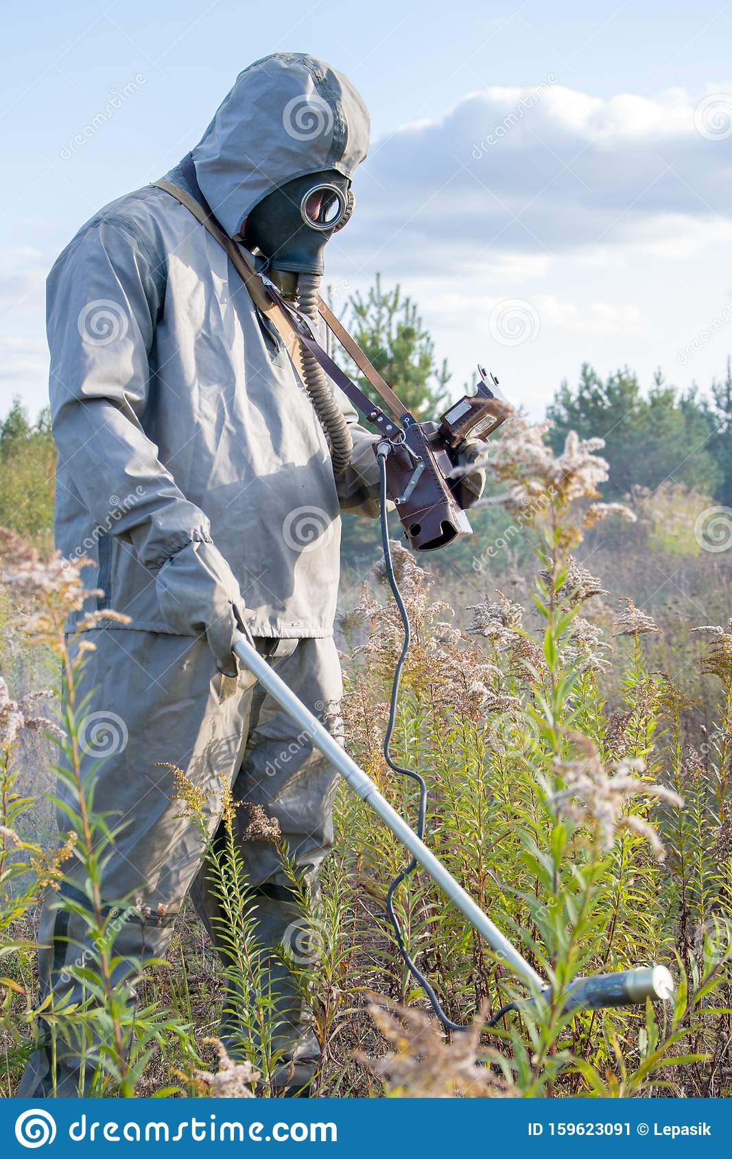 Military Dosimetrist Measures Radiation On A Grassy Area. Chemical Protective SUIT And Gas MASK, Sunny Day Stock Image - Image of ecology, checks: 159623091